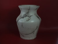 a white vase on a red background