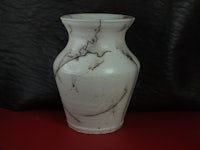 a white vase with black lines on it